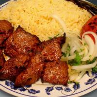 Pork Kebab · Pork kebab with rice, a side salad a roasted tomato and jalapeno.