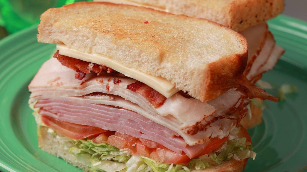 Deli Club  · Turkey, ham, bacon, white American cheese, lettuce, tomato, onion, and mayo on sourdough bread.