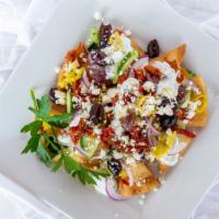 Greek Nachos · Crispy pita chips topped with sun dried tomatoes, pepperoncini peppers, cucumber, onion, kal...