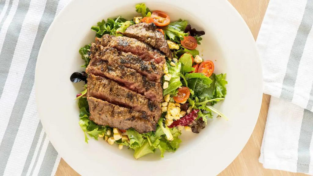 Steak Salad · Wagyu skirt steak, mixed greens, roasted corn, grape tomatoes, cilantro lime vinaigrette.