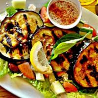 Eggplant Salad · Freshly grilled eggplant served with tahini sauce on top of the healthy Greek salad served w...