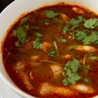 Tom Yum Large · Our spicy-sour soup is served simmering with straw mushrooms, lemongrass, galangal, green on...