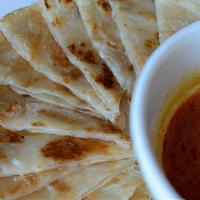 Roti Canai With Curry Dip · Multi-layered flatbread served with curry dip.