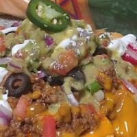 Royal Nachos · Served with warm freshly prepared tortillas chips house made cheese sauce onions tomatoes an...