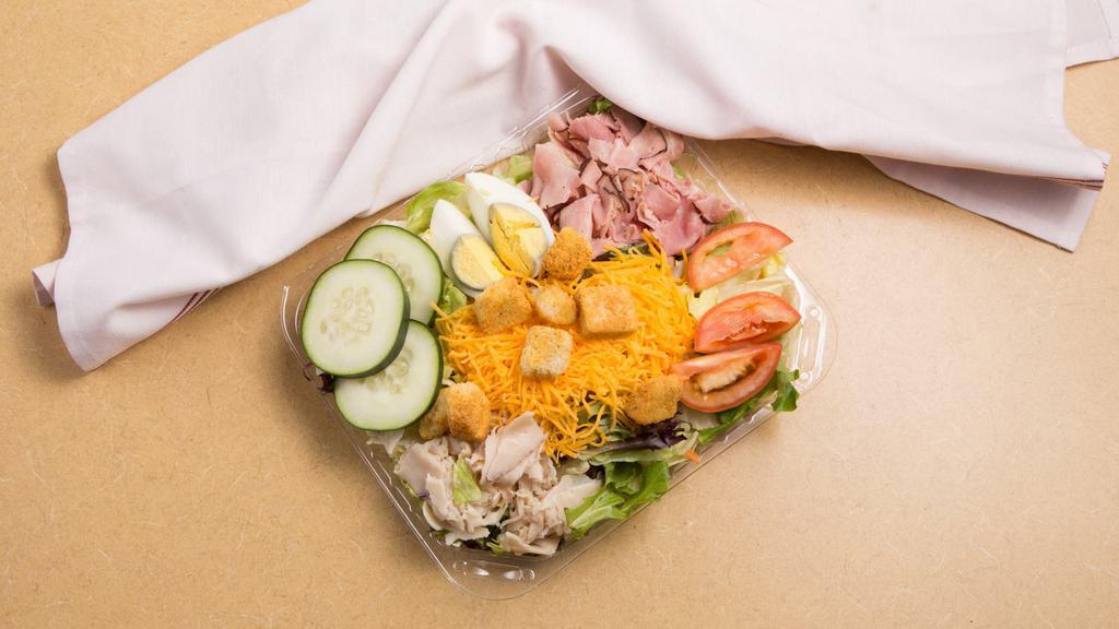 Chef Salad · Lettuce with mixed greens, turkey, ham, egg, tomato, cucumber and Cheddar. Garnished with tomatoes.