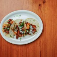 Tacos Al Pastor · Three soft tacos made with corn tortilla and filled with marinated pork loin strips, topped ...