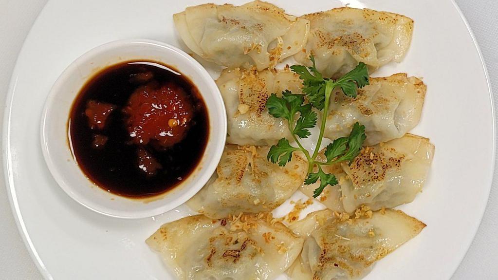 Mini Dumplings · 8 sautéed chicken potsticker dumplings topped with crispy garlic and cilantro. Served with house hot soy sauce.