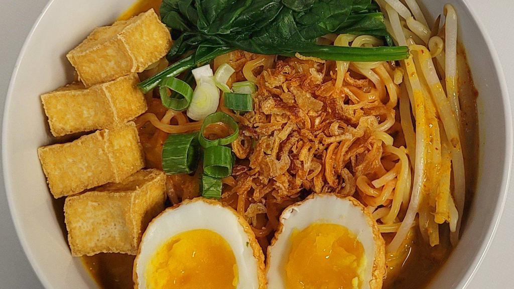 Fire Coconut Curry Ramen · Ramen noodles in spicy red curry coconut milk soup with fried tofu, Tiger Skin Egg (deep-fried boiled egg), bean sprouts, and spinach. Topped with crispy red onions and chopped scallions.
(Our Japanese style ramen noodle is wheat-based. Rice noodle substitute available.)