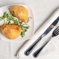 Vegetable Samosa · Savory deep fried pastry puffs filled with mildly spiced potato and peas.