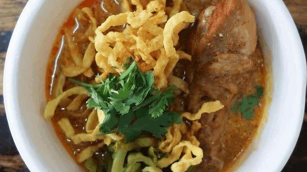 Khao Soi · Egg noodle, Crispy egg noodle, red onion, green onion, pickle mustard, cilantro and bean sprout in curry soup broth.