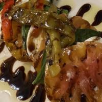 Caprese · Heirloom tomatoes, mozzarella di buffalo, and fresh basil finished with a balsamic drizzle (...