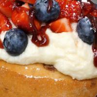 Very Berry Roll · crème brûlée frosting topped with fresh strawberries, blueberries, raspberry jam and powdere...