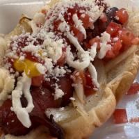 Sonora Style Hotdog · Topped with grilled onions, tomatoes, ketchup, mustard, mayo, cotija cheese and wrapped in b...