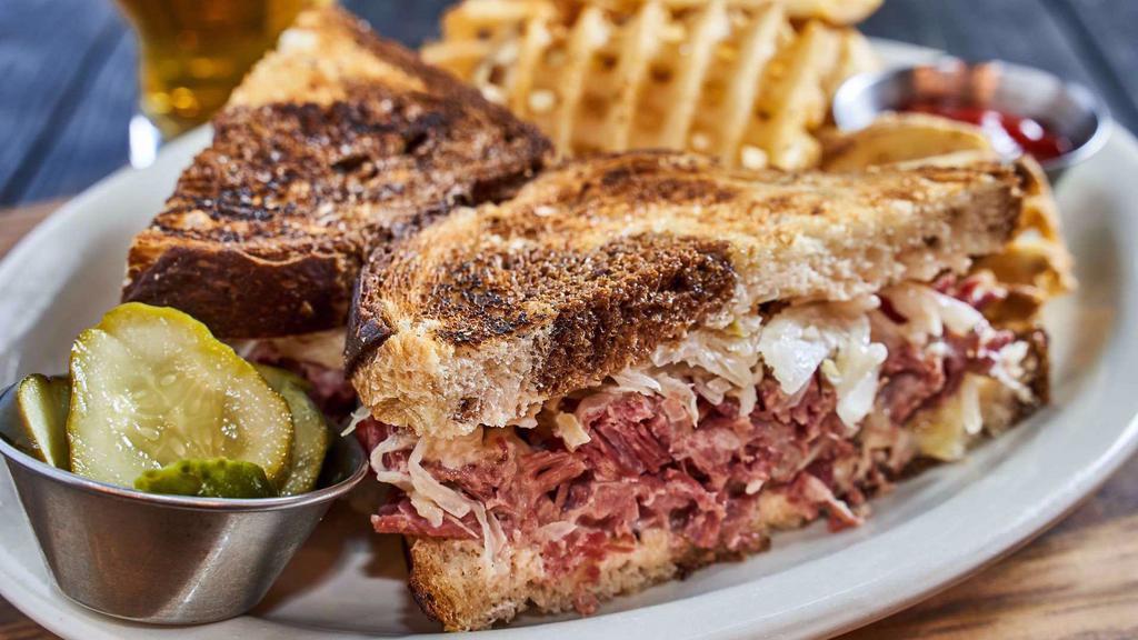 Reuben Sandwich · House-made corned beef brisket, sauerkraut, Swiss cheese, and Russian dressing on grilled marble rye. It includes house-made Arizona gold butter pickles. Served with your choice of side.