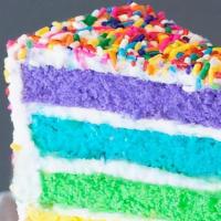 Rainbow Cake Slice · Six layers of rainbow-colored vanilla cake filled high with a sweet vanilla buttercream, cov...