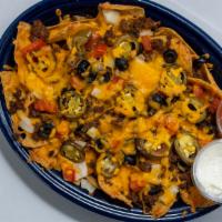 Nachos · Chips, cheddar cheese, taco meat, onions, black olives, tomato and  jalapeños.