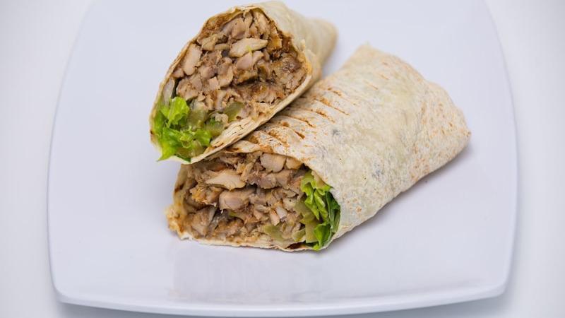 Chicken Shawarma Wrap · Thinly sliced slow roasted chicken, red onion, pickles, lettuce, garlic, and tahini sauce.