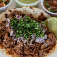 Birria Taco · Shredded beef street taco seasoned with chili's and spices of garlic, clove and cumin. Toppe...