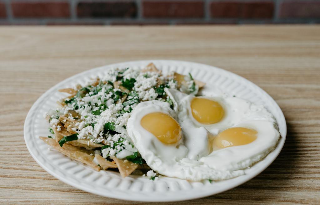 Chilaquiles With Eggs · Tortilla chips covered in green salsa, topped with onions, cilantro, and queso fresco served with 3 eggs. Extra toppings for an additional charge.