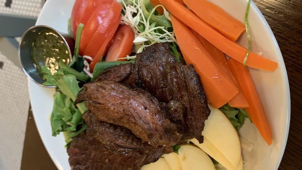 Carne Asada Salad · Grilled, seasoned steak* over a fresh garden salad, sweet potato and apple dressed in a lime tomatillo vinaigrette.