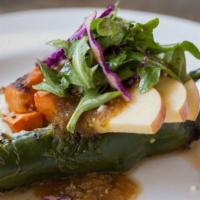 Chile Relleno · A fire-roasted poblano pepper stuffed with quinoa, sweet potato, and apples, topped with que...