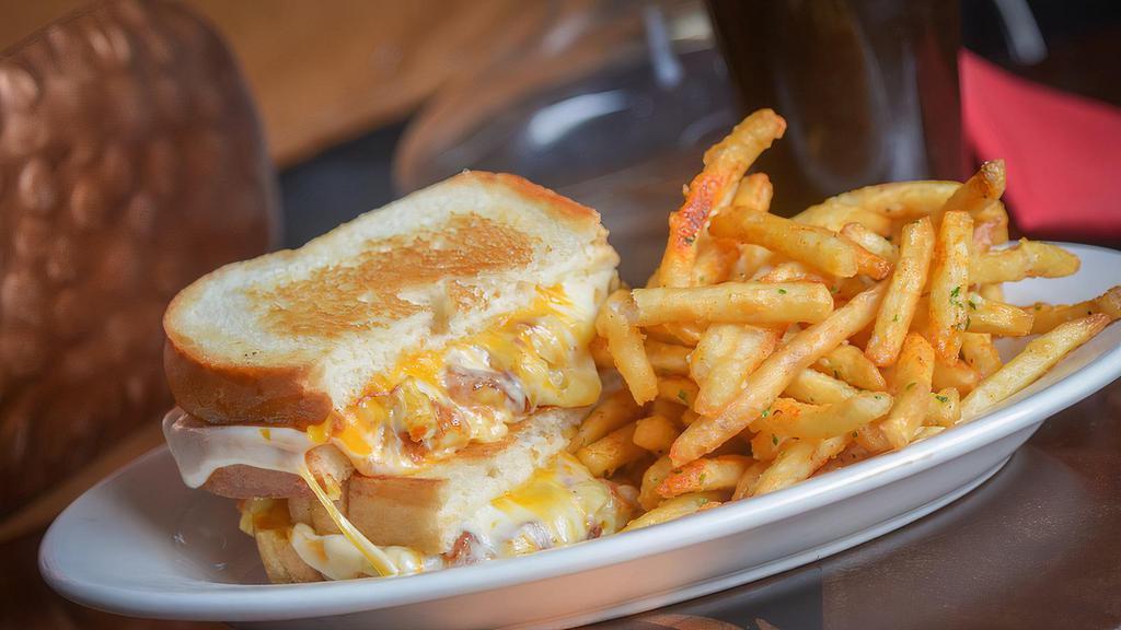 Mac And Cheese Grilled Cheese · Crispy Mac & Cheese Filling, Muenster & Cheddar Cheeses Served on a Toasted Butter Bread with Cajun Garlic Fries.