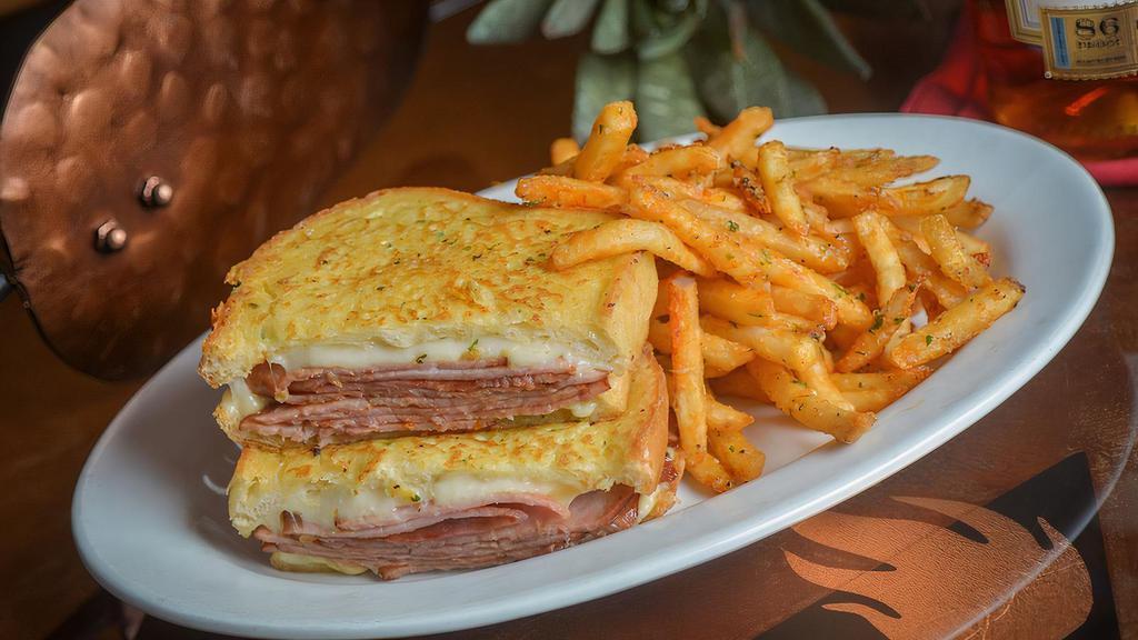 The Count Of Monte Cristo · Shaved Ham, Swiss Cheese, Roasted Garlic & Herb Mayonnaise, Dipped in a Parmesan Herb Egg Wash served on Toasted Butter Bread with Cajun Garlic Fries.