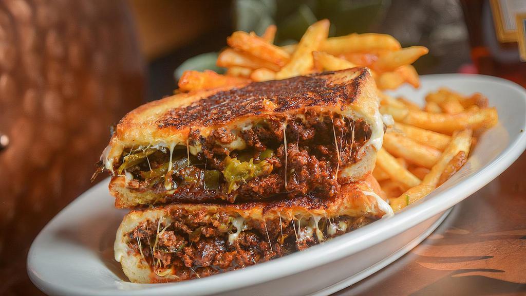 Dirty Pablo Grilled Cheese · Beef Chorizo, Smoked Poblano Peppers, Oaxaca Cheese, Red Chile Glaze served on a Toasted Butter Bread with Cajun Garlic Fries.