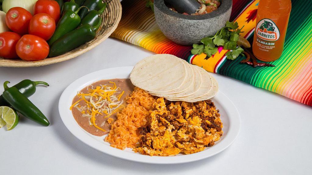 Breakfast Plate · Two scrambled eggs with choice of meat served with a side of refried beans, spanish rice, and choice of corn or flour tortillas.