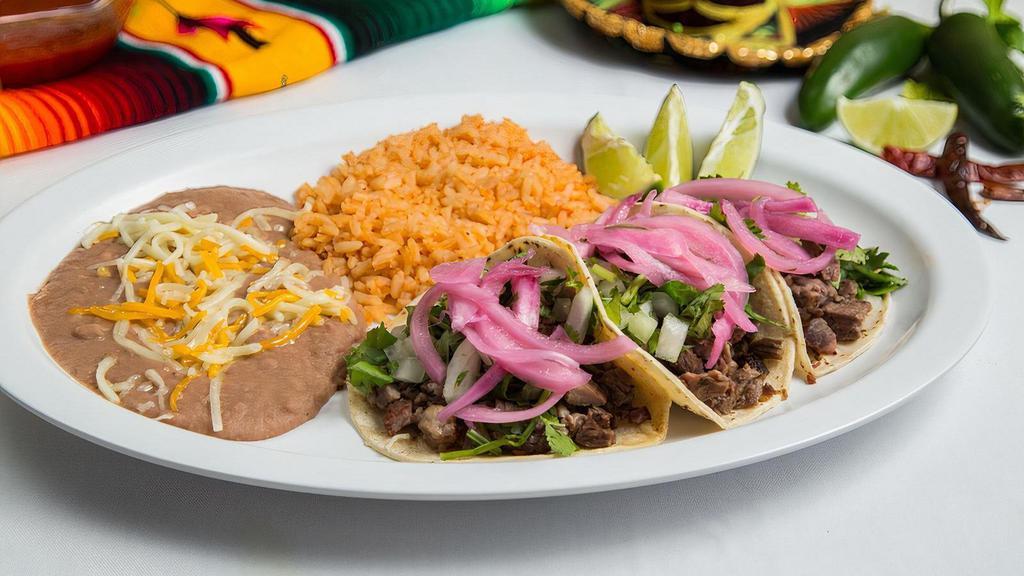 Three Taco Plate · Three tacos with choice of meat & tortilla shells served with lettuce, tomato, cheese and a side of refried beans and spanish rice