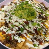 Zipper Nachos · Choice of protein, nacho cheese, crema, onions, cilantro and guac on house fried corn chips....
