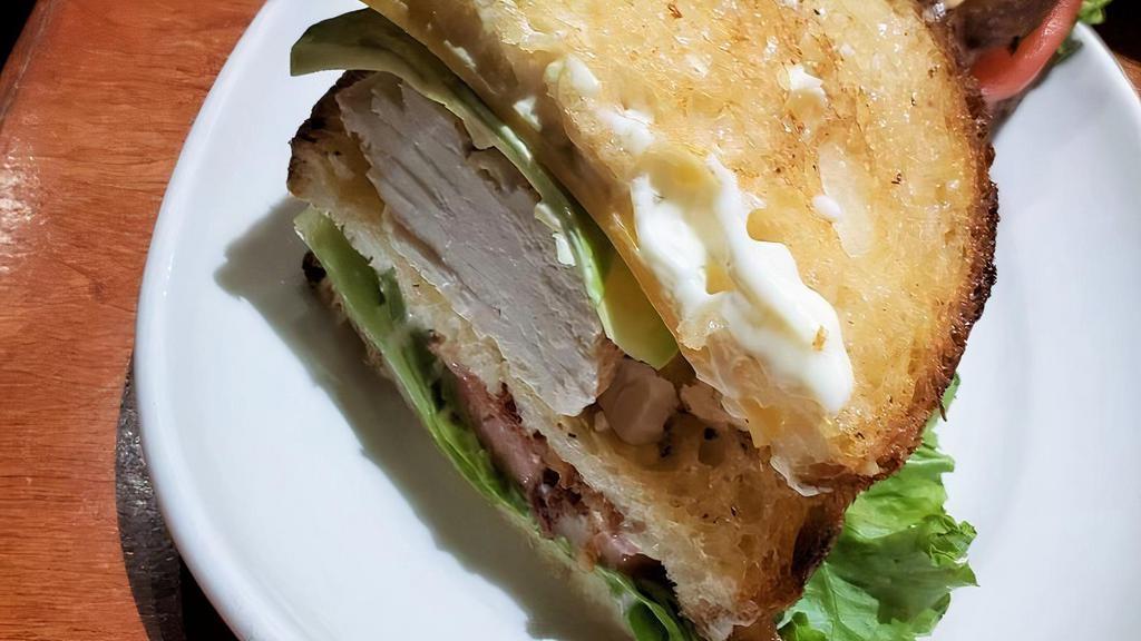 Turkey Club · In-House Roasted Turkey Breast, Lettuce, Smoked 
Bacon, Tillamook Cheddar Cheese, Avocado, Tomato + Mayo.  On Three Slices Of Grilled Sour White Bread.