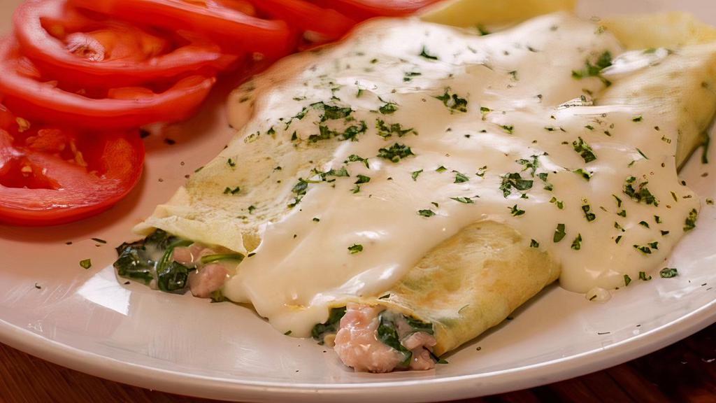 Ham, Spinach & Swiss Crepe Breakfast · Delicate crepes filled with fresh baby spinach, fresh ground ham, Swiss and bechamel cheese. Served two to a plate, with your choice of side.