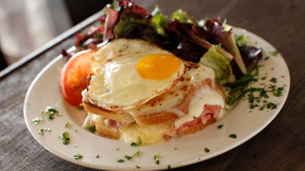 Croque Madame Breakfast · With sunny side egg on top. Thinly sliced ham, layered with bechamel, Gruyere and Parmesan cheese baked on our box French bread.