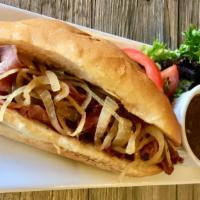Le Bifteck Sandwich · Prime roast beef with sautéed onions and garlic stuffed into a French baguette with a side o...