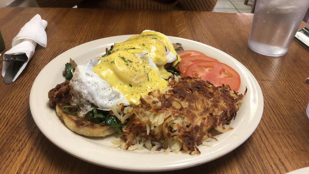 Bacon Florentine Benedict · Grilled English muffin halves, bacon, spinach, mushrooms, basted eggs, hollandaise sauce, and chives. Served with tomatoes and hash browns.