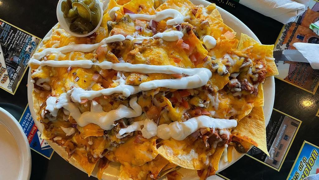Nachos · Fresh tortilla chips topped with our own zesty Arizona chili, smothered in melted monterey jack and cheddar cheeses, diced tomatoes, chopped red onions, sliced jalapeno peppers and sour cream.