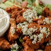 Buffalo Chicken Salad · Fresh romaine lettuce tossed with blue cheese crumbles, bacon, diced tomatoes, topped with a...