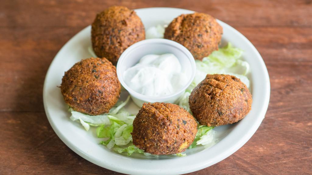 Falafel (5 Pcs) (V) · Chickpea and fava beans ground with vegetables and spices. Served with tahini sauce, tomatoes and pickles. Vegetarian.