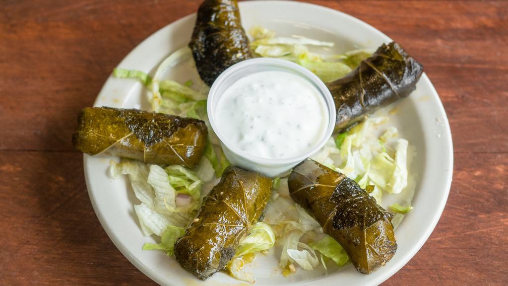 Grape Leaves (5 Pcs) (V) · Rolled grape leaves stuffed with rice, onions, tomatoes and parsley. Cooked in seasoned lemon sauce served with a side of taztziki. Vegetarian.