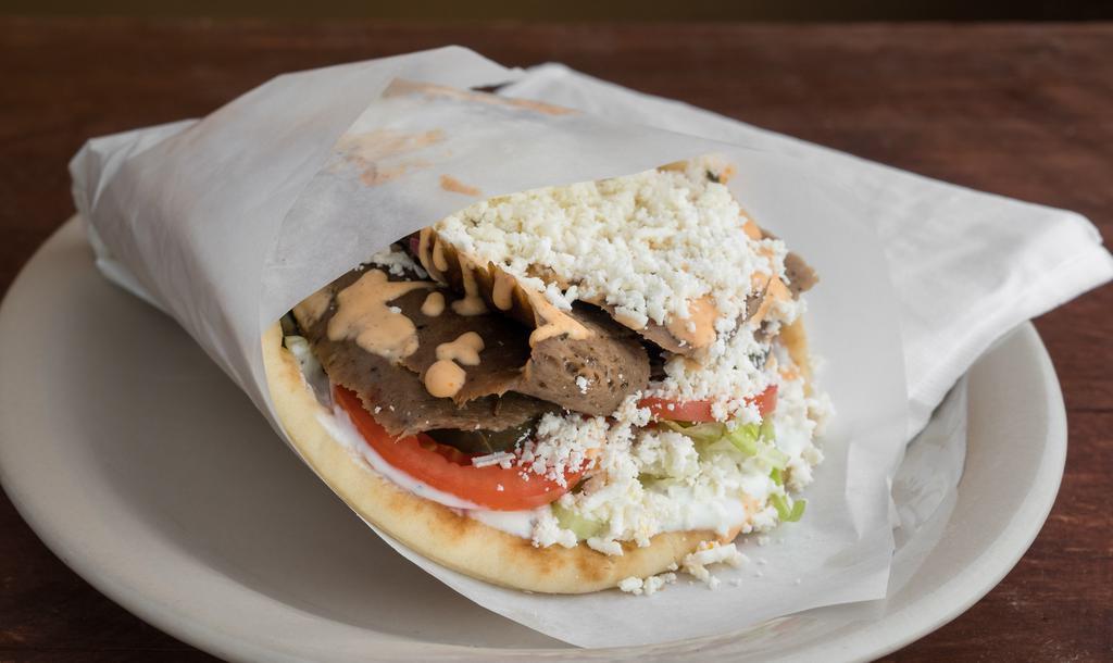 Traditional Lamb Gyro · Fire grilled lamb/beef gyro strips served in a pita bread with tomatoes, pickles, lettuce and onions topped with tzatziki sauce.