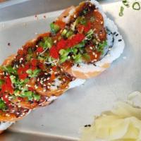 Mad Salmon · California roll. Topped w/ salmon, jalapeno slices, tobigo, green onion and sesame seeds. Un...