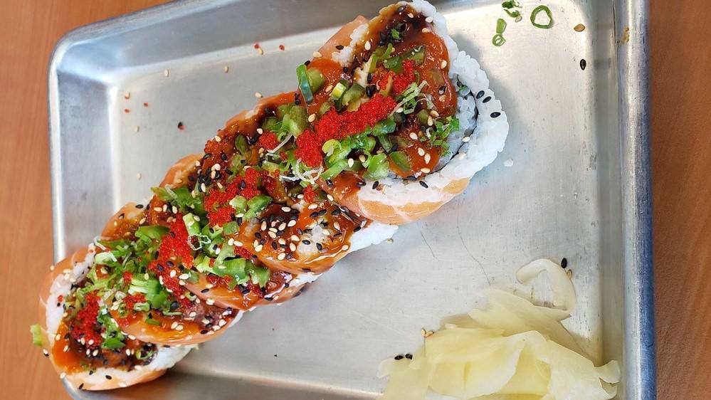 Mad Salmon · California roll. Topped w/ salmon, jalapeno slices, tobigo, green onion and sesame seeds. Unagi sauce and spicy sauce.