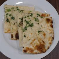 Garlic Naan. · Flat bread cooked in traditional clay oven and topped with butter and garlic.