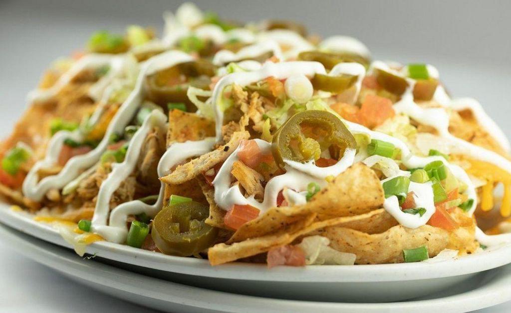 Chicken Cheese Nachos · Freshly fried tortilla chips layered with our own queso sauce, cheddar, and pepper jack cheese, grilled chicken, green onion, shredded lettuce. jalapeños, diced tomato, and sour cream.