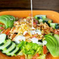 Fiesta Chicken Salad · Grilled chicken breast layered on top of mixed greens, topped with cheese, tomatoes and avoc...