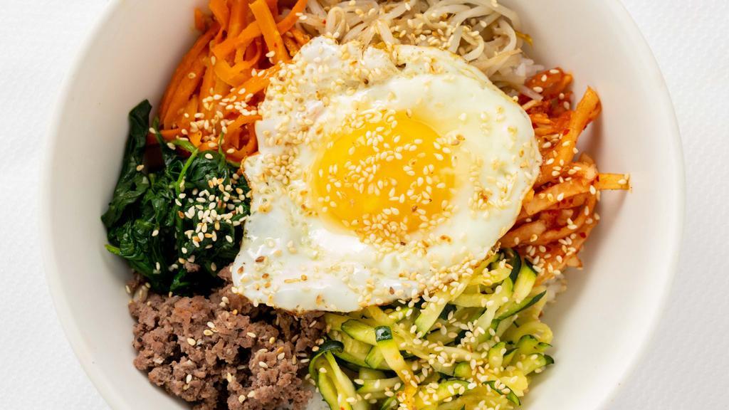 Bibimbap  · Rice mixed with steamed vegetables, beef and an over-easy egg.
