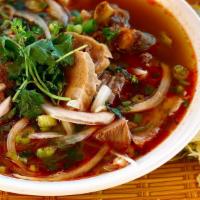 Spicy Beef Noodle Soup · Spicy noodle soup with beef, meatball, tendon, and ham. Served with scallions, onions, and c...