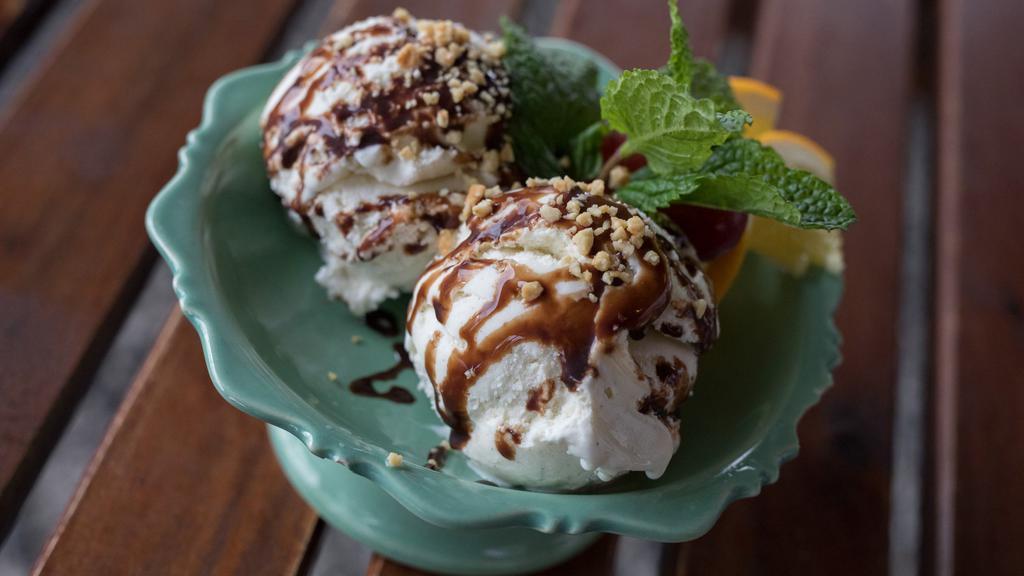 Tillamook Vanilla Ice Cream · An ice cold scoop of vanilla bean ice cream drizzled with chocolate sauce.