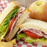 The Classic · Choice of turkey, ham or roast beef, Swiss or cheddar, tomato, lettuce and mayonnaise on sli...